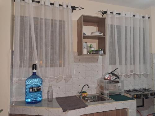 a bottle of water sitting on a counter in a kitchen at Town Stays in Voi