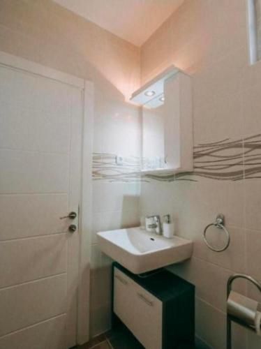 a bathroom with a white sink and a mirror at Evropa Sombor in Sombor