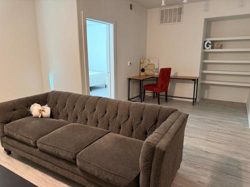 a living room with a brown couch and a table at Experience the Best of Fort Worth Stylish Apartment in the Cultural District in Fort Worth