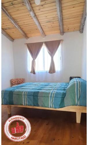 a bed in a room with a window at LOS CACTUS in Malargüe