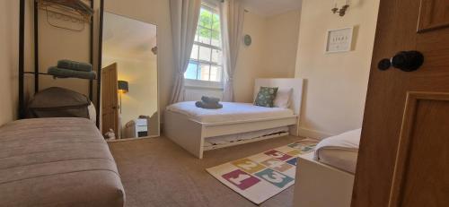 a small room with a bed and a mirror at Windsor Castle amazing Cottage in Windsor