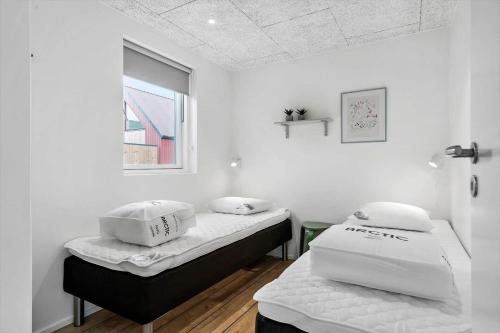 two beds in a room with white walls and a window at 940-Hvide-Sande-Langsand-169 in Hvide Sande
