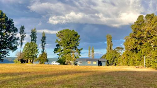 a house in the middle of a field with trees at Cabaña con jacuzzi exterior y vista al mar - Huellas de Pato, Puerto Montt in Puerto Montt