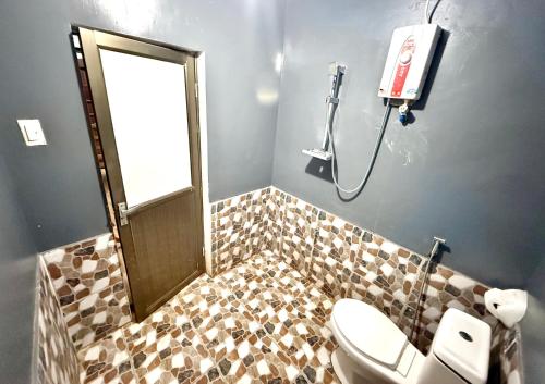 a bathroom with a toilet and a shower with a mirror at Mount Avangan Eco Adventure Park in Coron