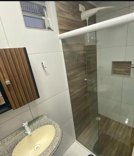 a bathroom with a sink and a glass shower at ML Integra Mix kitnets in Maceió