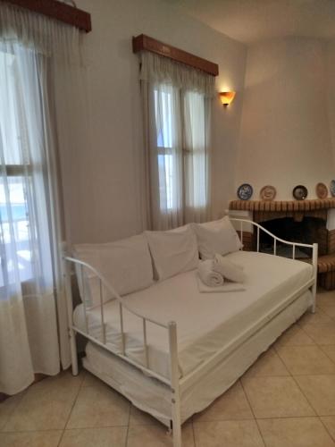 a white couch in a living room with windows at Margarita's home in Nísos Skýros