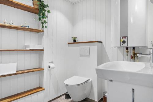 a white bathroom with a toilet and a sink at 319-Hvide-Sande-Gammeleng-16 in Hvide Sande