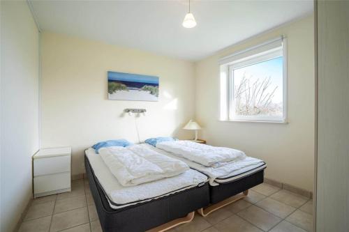 a bedroom with a bed and a window at 769-Hvide-Sande-Norregade-4-C in Hvide Sande