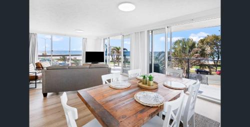 a living room with a table and chairs and a couch at Hi Surf Beachfront Resort Apartments OFFICIAL SITE in Gold Coast