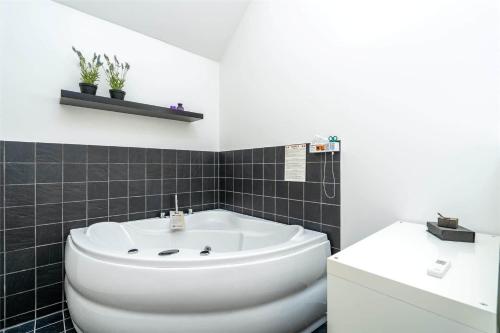 a bathroom with a white tub and a sink at 753-Hvide-Sande-Slusen-53 in Hvide Sande
