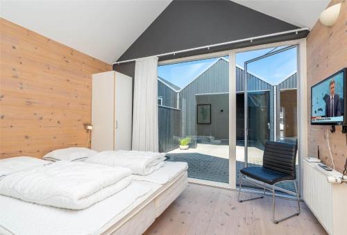 a bedroom with a bed and a sliding glass door at 753-Hvide-Sande-Slusen-53 in Hvide Sande