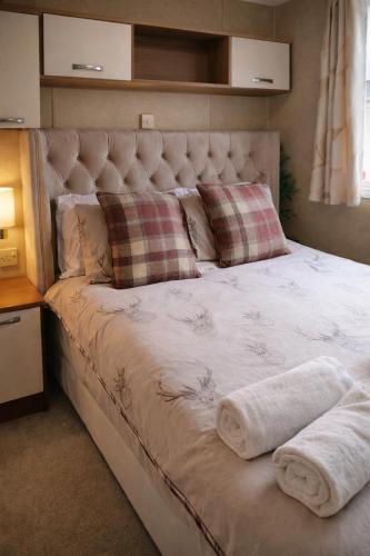 a large bed with two towels on top of it at Clwyd 6 in Borth