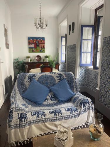 a bedroom with a bed with blue pillows on it at Patio da Foz - Appartement très accueillant centre-ville in Figueira da Foz