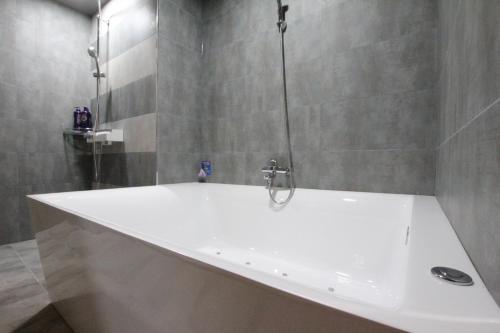 a white bath tub in a bathroom with a shower at Novahotel in Samgong