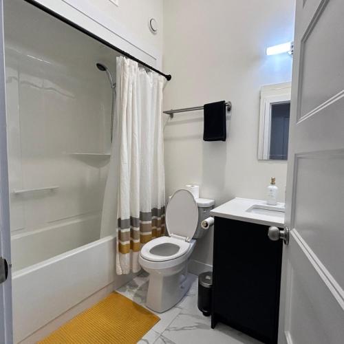 a bathroom with a toilet and a sink and a shower at Spacious Family Suite with private Kitchenette and Laundry in Halifax