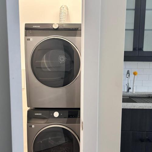 a microwave and a washing machine in a kitchen at Spacious Family Suite with private Kitchenette and Laundry in Halifax