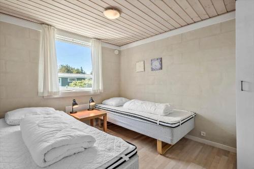 two beds in a room with a window at 355-Hvide-Sande-Fyrmarken-54 in Hvide Sande