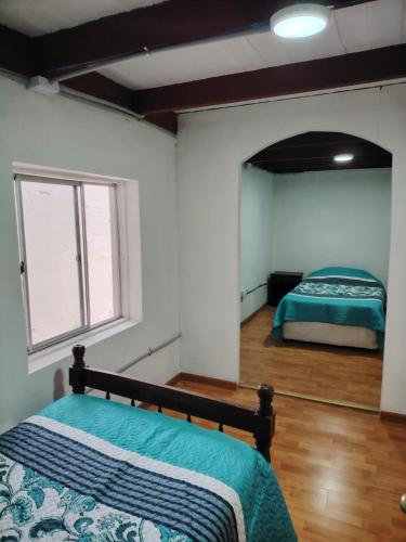 a bedroom with two beds and a window at Iquique Backpackers Beach House in Iquique