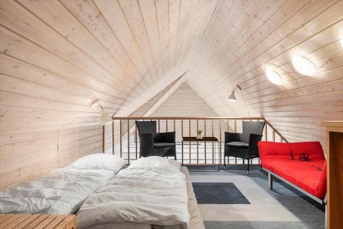 a room with a bed and a red couch at 5537-Hvide-Sande-Vesterledvej-14 in Havrvig