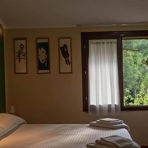 a bedroom with a bed and a window with pictures at Casa sul fiume con giardino e terrazza in Pianello