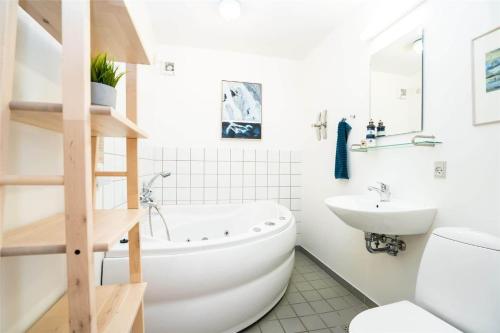 a bathroom with a white tub and a sink at 717-Hvide-Sande-Slusen-17 in Hvide Sande