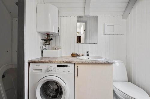 a bathroom with a washing machine and a sink at 602-Hvide-Sande-Nygardsvej-32 in Bjerregård