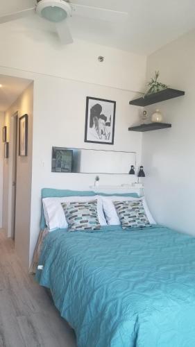 a bedroom with a large bed with a blue comforter at Sunvida tower Unit 1911 in front Sm Cebu in Cebu City
