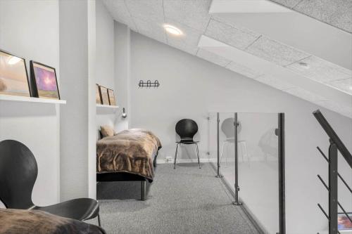 a bedroom with a bed and a chair in a room at 776-Hvide-Sande-Norregade-2-nr-27 in Hvide Sande
