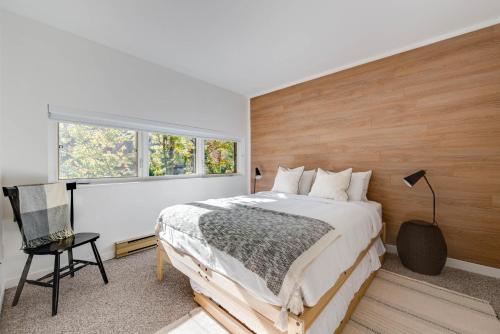 a bedroom with a large bed with a wooden wall at D-Chalet - 9 personnes - 2 chambres in Beaupré