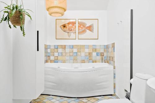 a bathroom with a white tub and a fish on the wall at 707-Hvide-Sande-Slusen-7 in Hvide Sande
