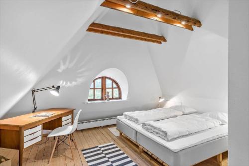a white bedroom with a bed and a desk at 5507-Hvide-Sande-Tornbjerrevej-56 in Havrvig