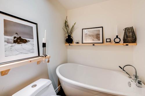 a bathroom with a white tub and a toilet at D-Chalet - 9 personnes - 2 chambres in Beaupré