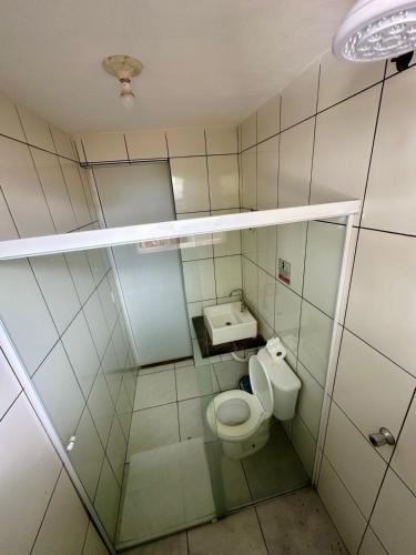 a small bathroom with a toilet and a sink at Ganesh Chalés in Boracéia