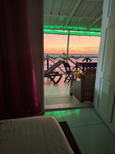 a room with a balcony with a table and chairs at Inn Skyline Hostel in San Andrés