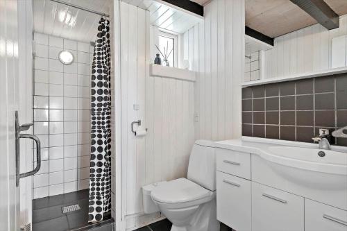 a white bathroom with a toilet and a sink at 311-Hvide-Sande-Fyrmarken-7 in Hvide Sande