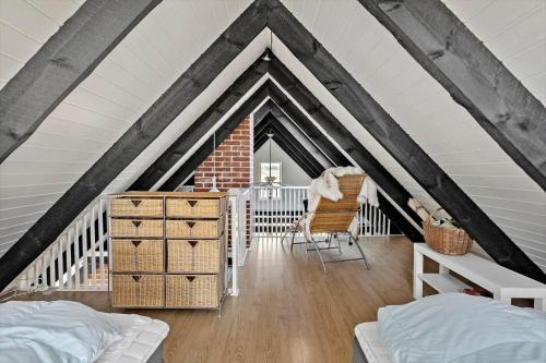 a attic room with a bed and a chair at 311-Hvide-Sande-Fyrmarken-7 in Hvide Sande
