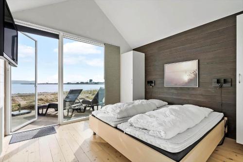 a bedroom with a bed and a view of the ocean at 703-Hvide-Sande-Slusen-3 in Hvide Sande