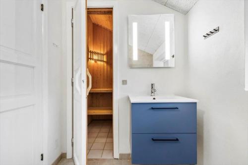 a bathroom with a blue cabinet and a sink at 513-Hvide-Sande-Riskrogvej-16 in Havrvig