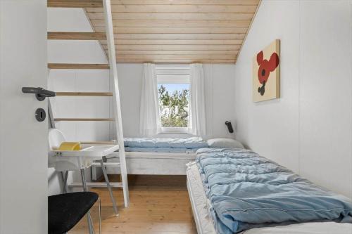 a bedroom with two bunk beds and a window at 6623-Hvide-Sande-Bilbergsvej-18 in Bjerregård