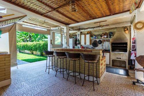 a kitchen with a bar with stools at Chácara Recanto do Sossego in Morretes