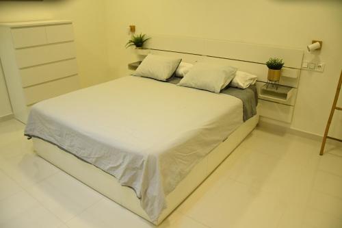 a bedroom with a large bed with white sheets and pillows at Caretta Beach Destino in Morro del Jable