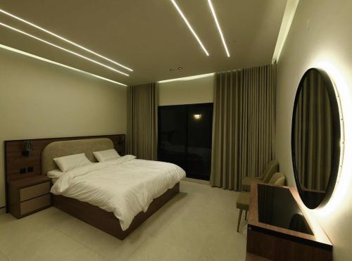 a bedroom with a bed and a mirror and a sink at شقة مشراق in Al-ʿUla