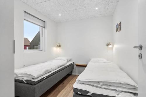 two beds in a white room with a window at 9953-Hvide-Sande-Langsand-212 in Hvide Sande