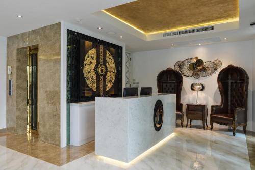 a lobby with a reception desk and chairs at Aspira G Sukhumvit 33 in Bangkok
