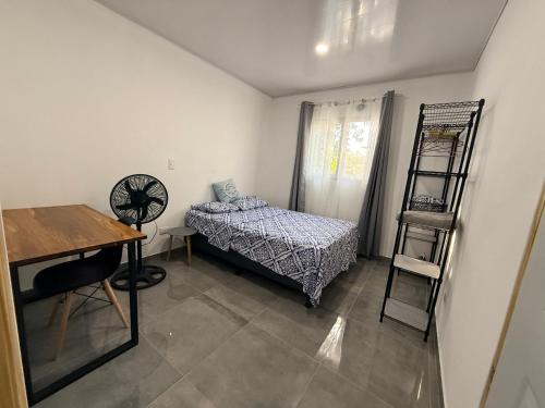 a small room with a bed and a desk at Villa Carpintera in Puntarenas