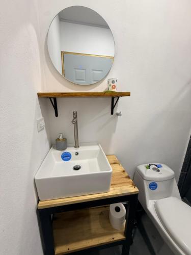 a bathroom with a sink and a mirror and a toilet at Villa Carpintera in Puntarenas