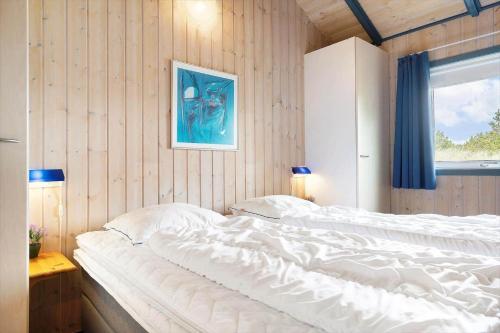 a large white bed in a room with a window at 604-Hvide-Sande-Bjerregardsvej-193 in Bjerregård