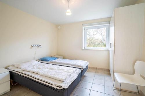 a bedroom with a bed and a window at 770-Hvide-Sande-Norregade-4-B in Hvide Sande