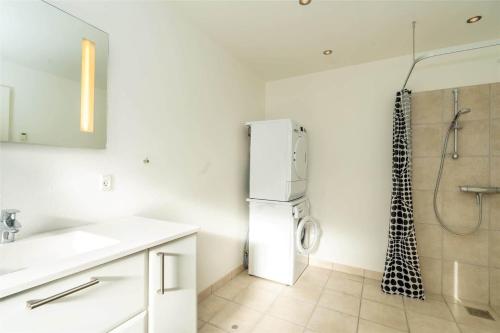 a white kitchen with a refrigerator and a shower at 770-Hvide-Sande-Norregade-4-B in Hvide Sande