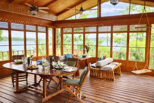 a dining room with a table and chairs and windows at Akwaba Lodge Island Boutique Hotel in The Gap